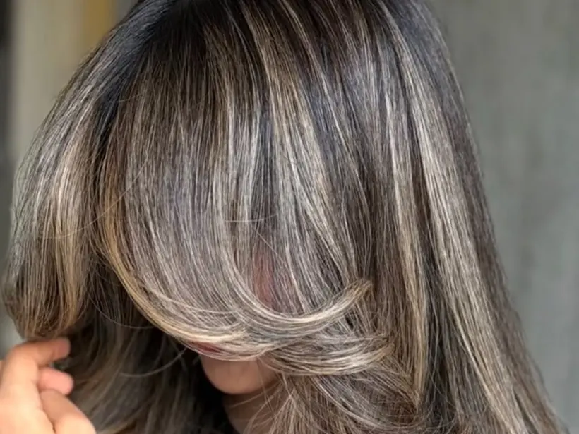 Balayage blond avec frange rideau réalisé au salon