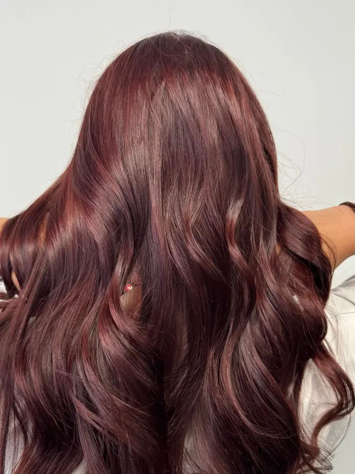 Coloration rouge acajou sur cheveux longs ondulés
