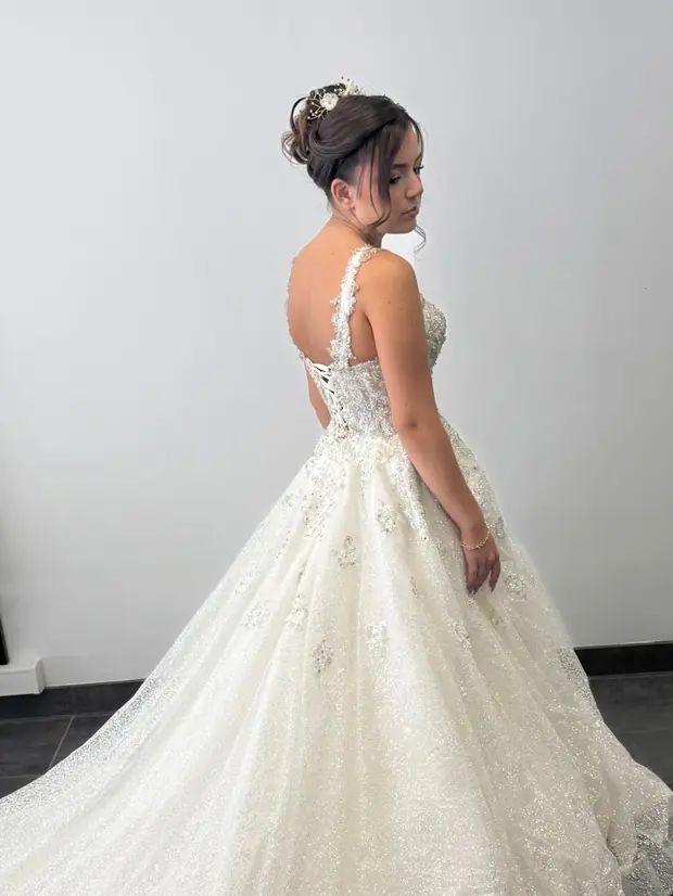 Mariée en robe à traîne, chignon haut orné